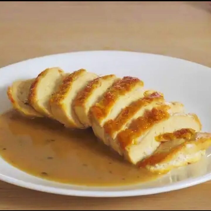 plate with sliced chicken breast and a chicken pan sauce