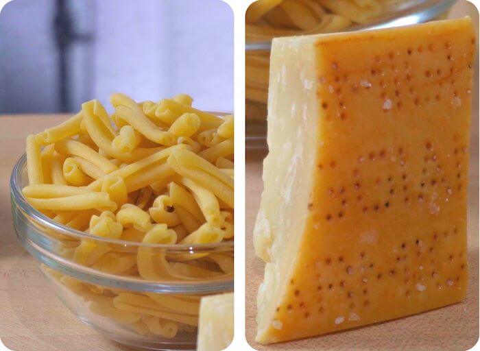 dried pasta in a bowl with block of parmesan