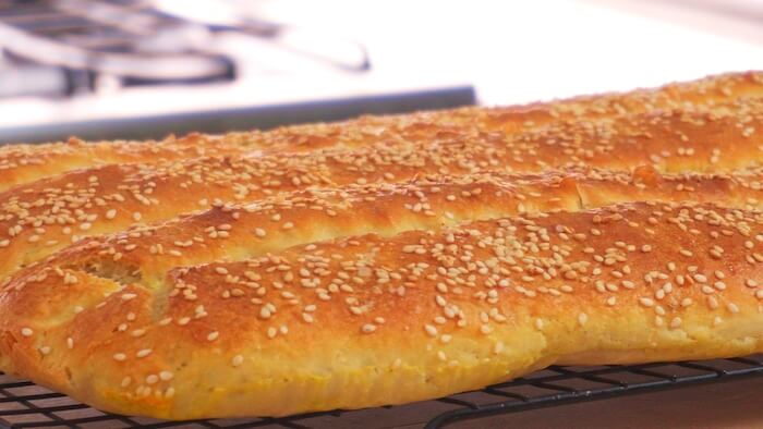 close up of the baked bread with a golden crust and topped with sesame seeds