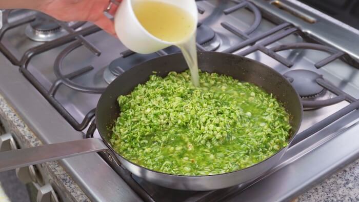 stock being poured into pan of rice