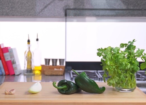 ingredients on a chopping board, garlic, onion, coriander, poblano pepper