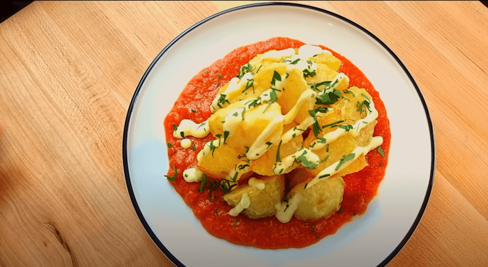 finsihed plate of patatas bravas with aioli and parsley