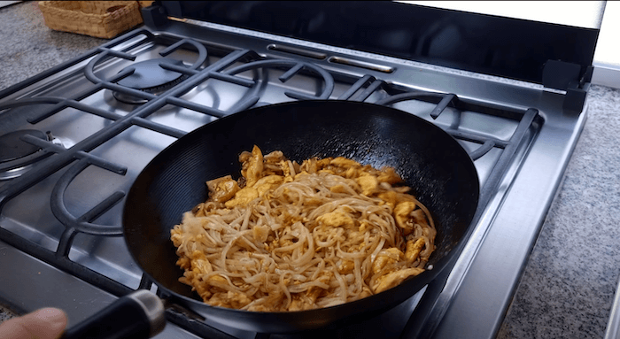 pad thai stir fry being cooked in a wok