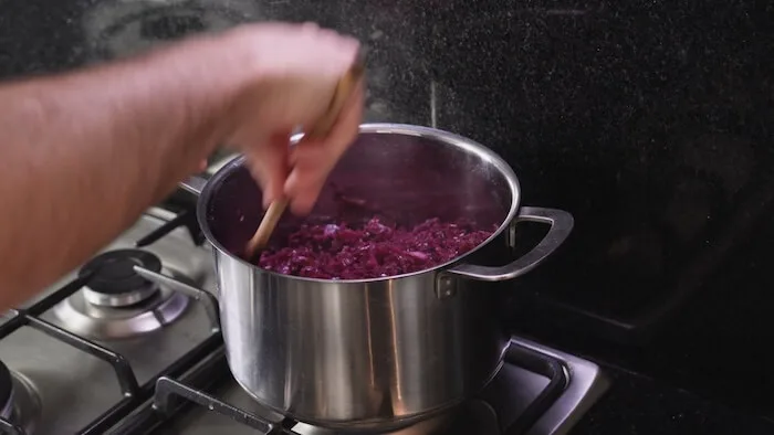 saucepan on a stove top, with red cabbage being cooked