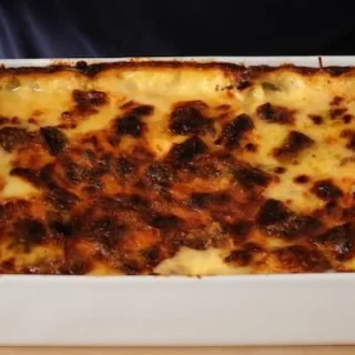 a tray of Gratin leeks being held by two hands