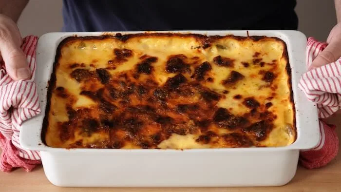 a tray of Gratin leeks being held by two hands