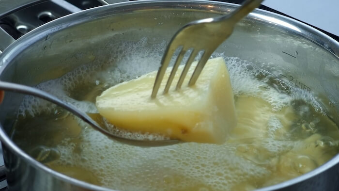 a fork testing boiled potatoes tenderness