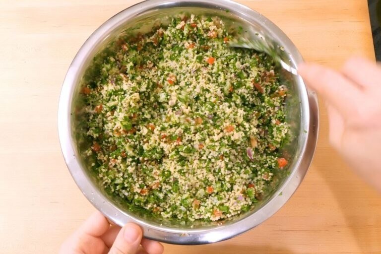 bowl of tabbouleh with couscous, herbs and vegetables