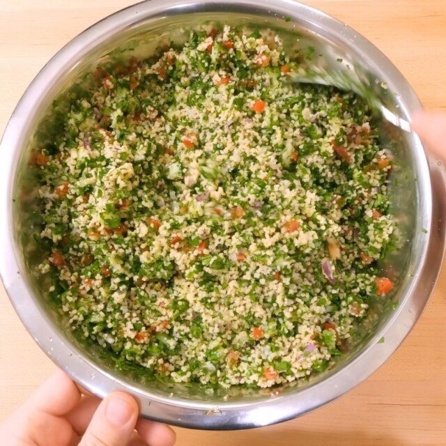 bowl of tabbouleh with couscous, herbs and vegetables