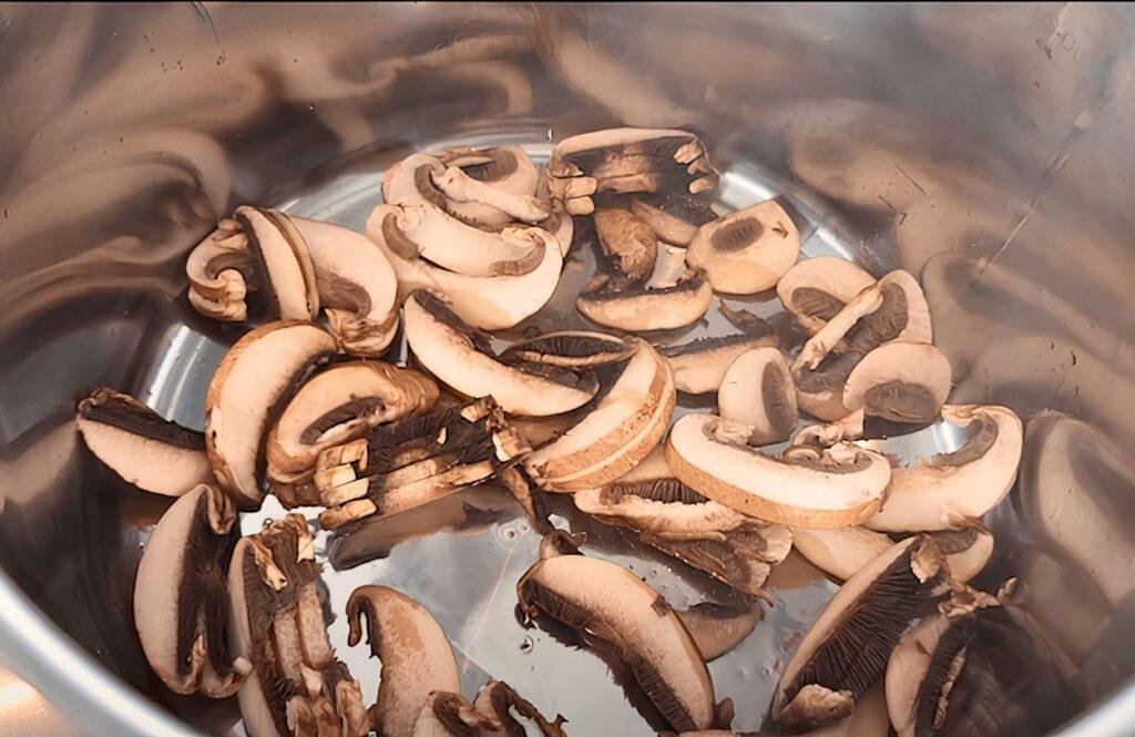 Sliced chestnut mushrooms in a steel pot