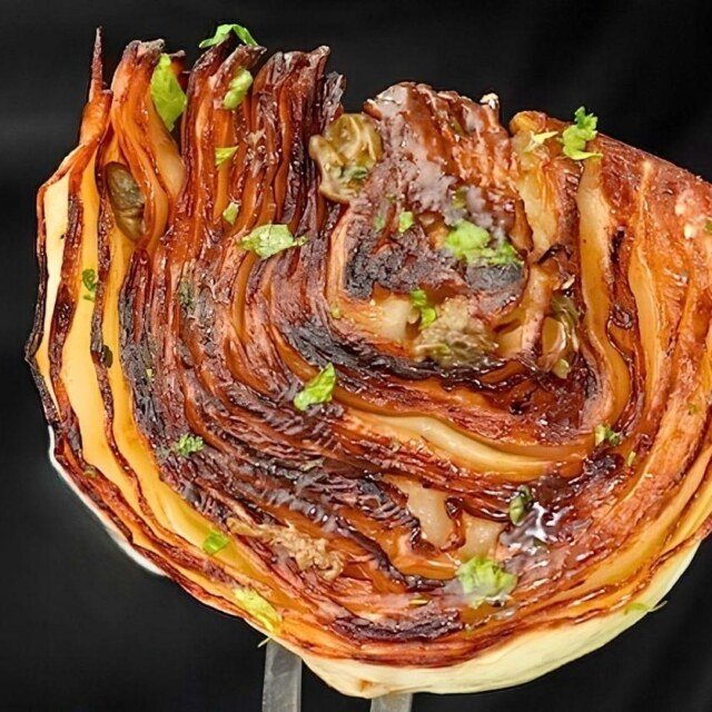 fork holding up caramelised piece of pan roasted cabbage