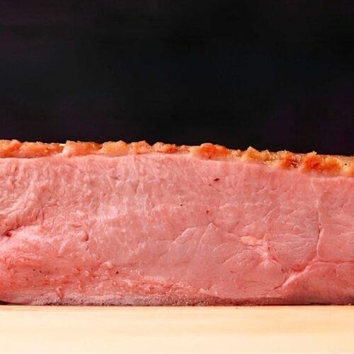 pink duck breast with crisp golden fat, sliced in half