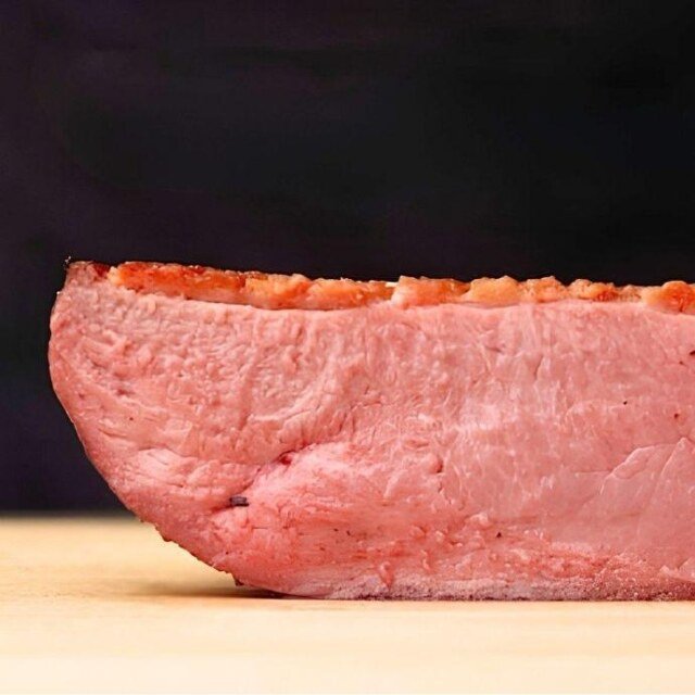 pink duck breast with crisp golden fat, sliced in half