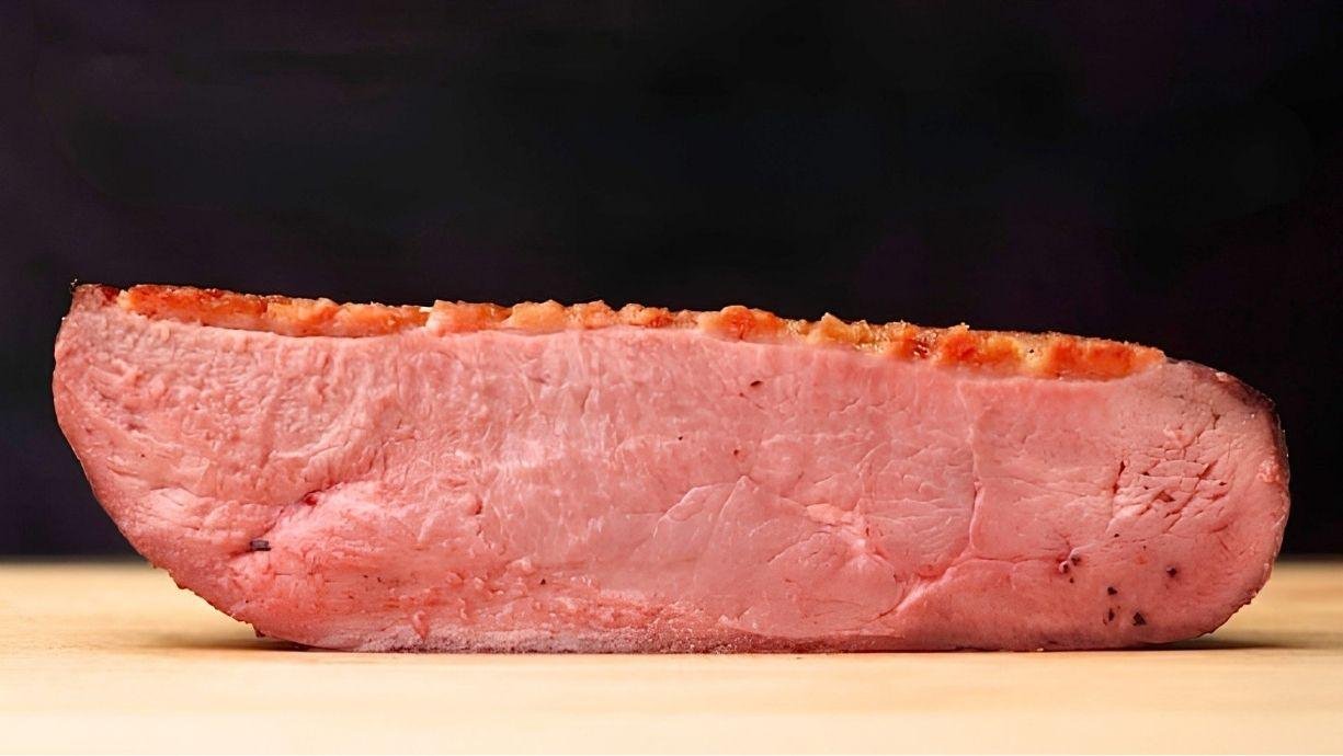 pink duck breast with crisp golden fat, sliced in half