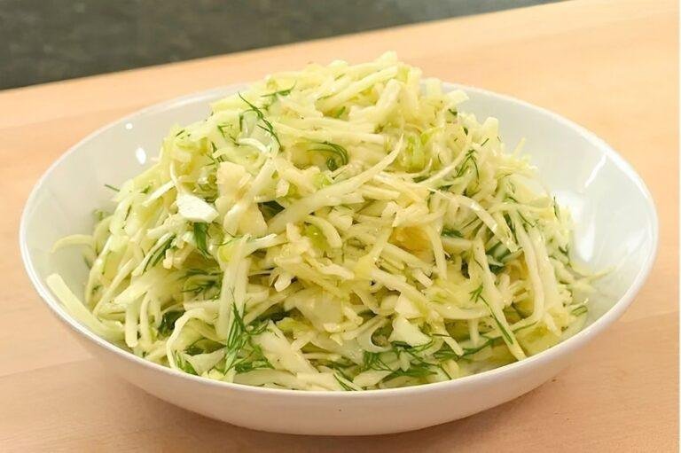 White bowl of shredded cabbage slaw with dill