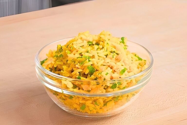 yellow rice in a bowl on wooden surface