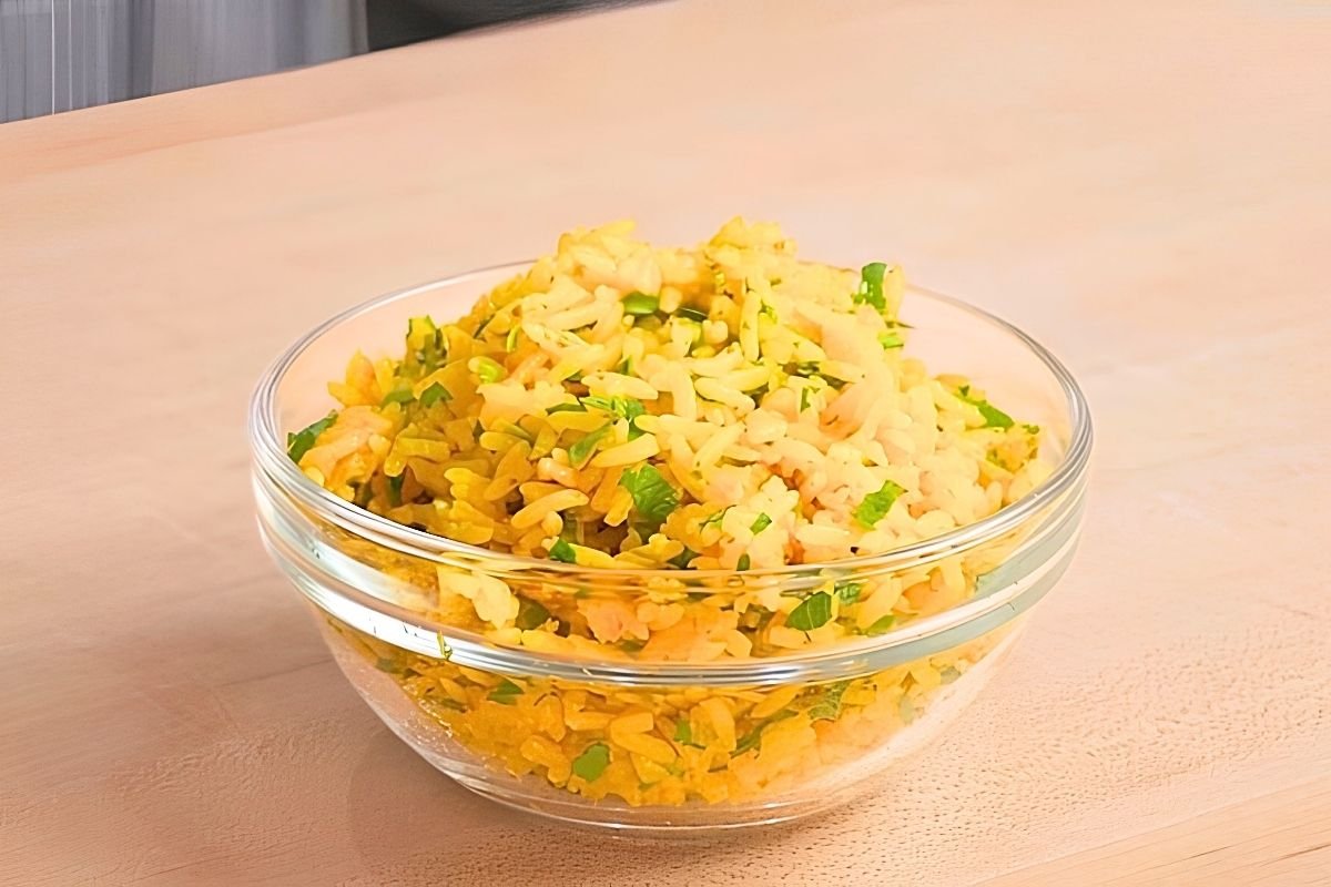 yellow rice in a bowl on wooden surface