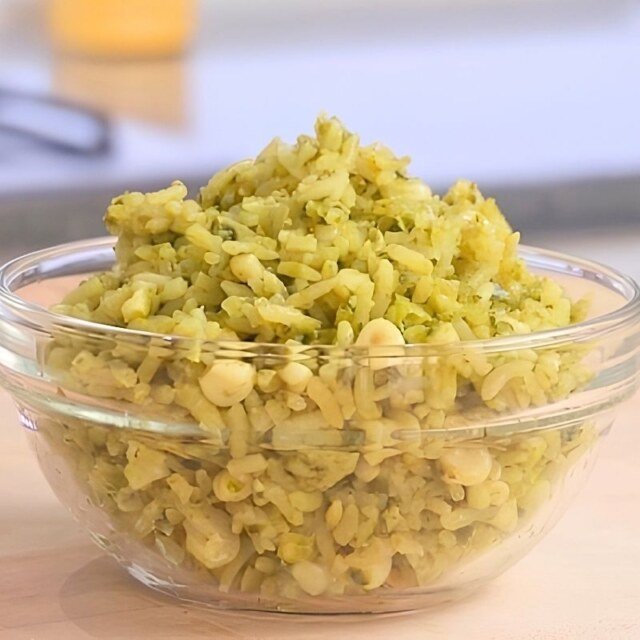 green rice in a bowl on a wooden counter top