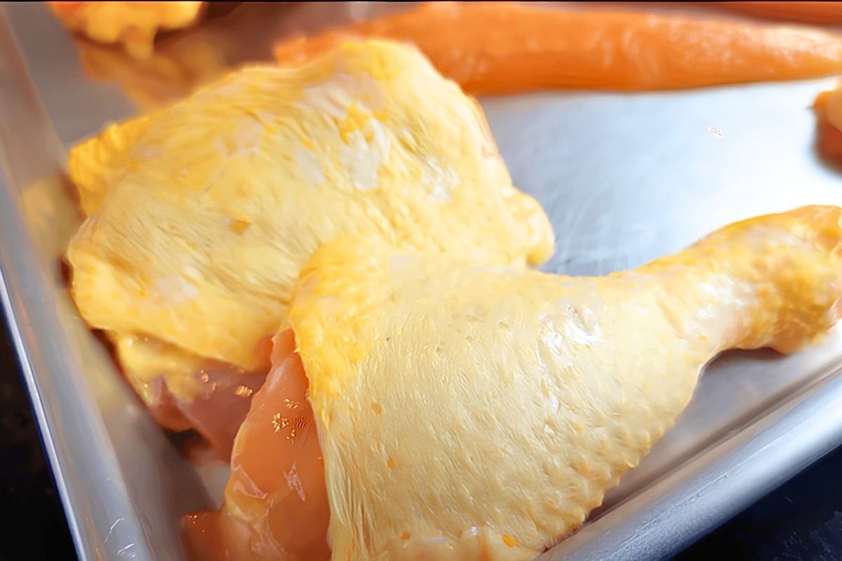 Raw chicken leg and thigh on a metal tray after being prepared