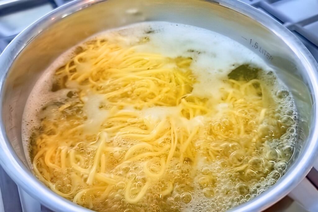 Noodles boiling in a pot, illustrating a key step in the chicken noodle soup recipe.