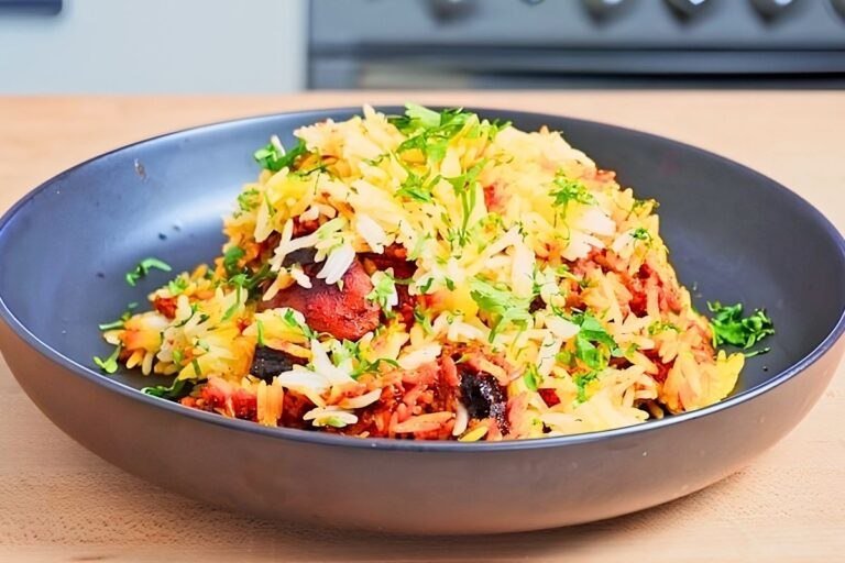 Bowl of cooked rice and chicken with herbs and spices