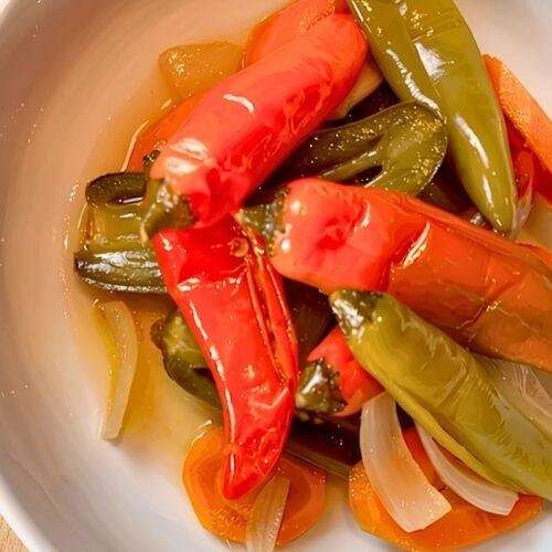 Bowl of pickled escabeche chillies with carrot and onion
