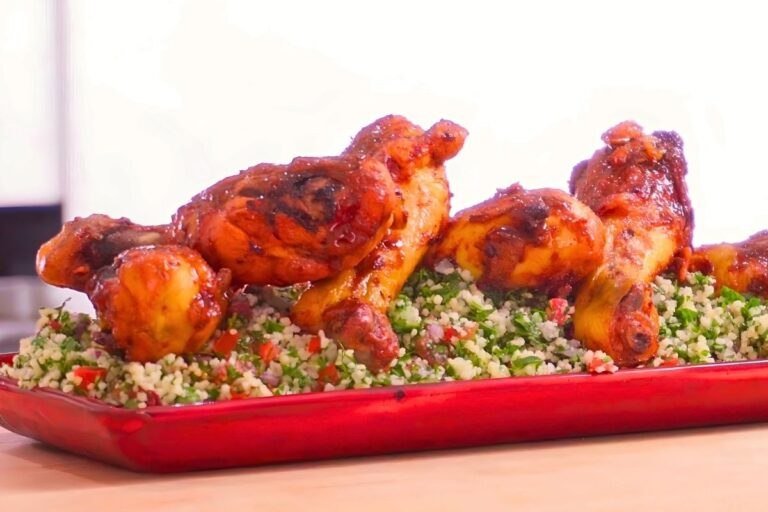 Glazed chicken drumsticks served over tabbouleh on a red platter