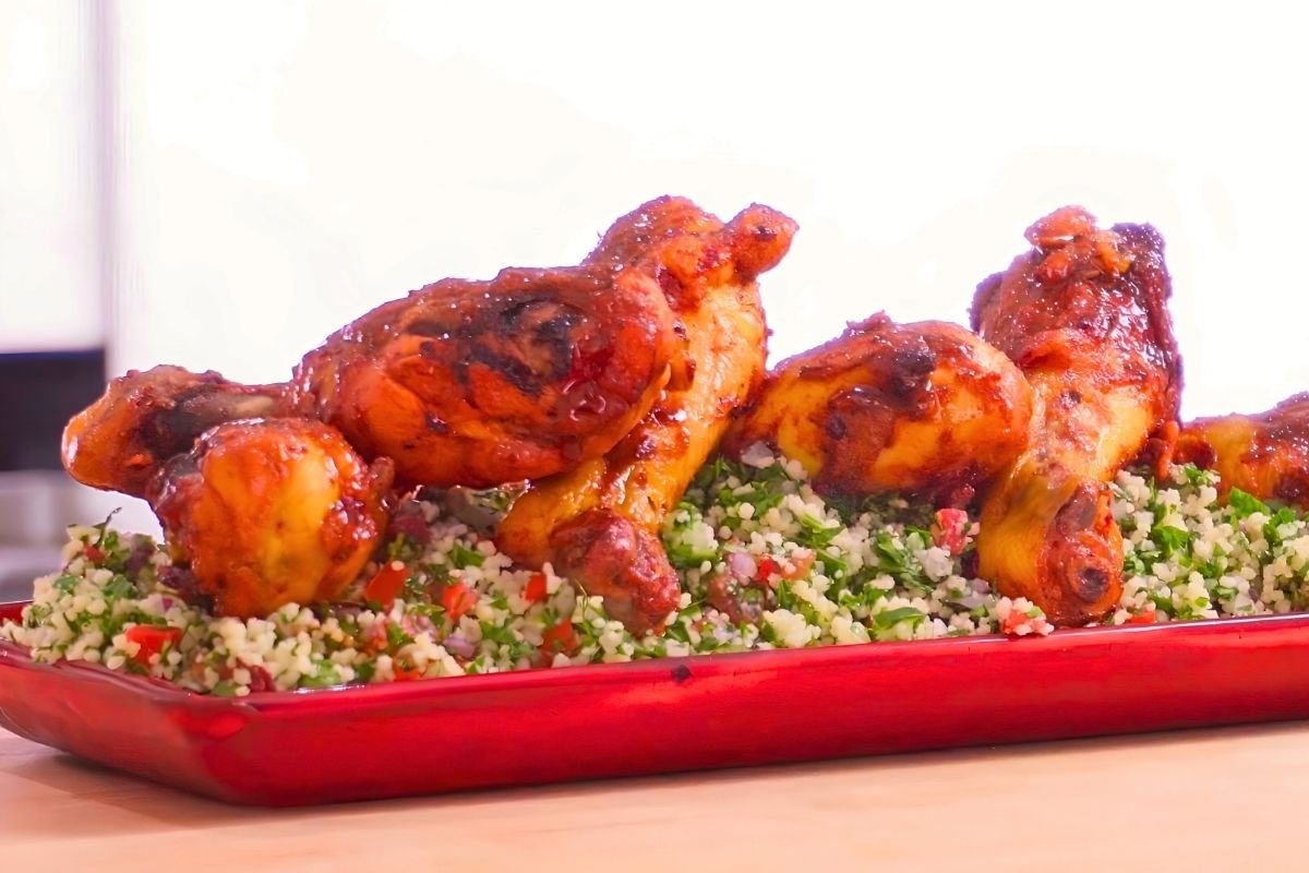 Glazed chicken drumsticks served over tabbouleh on a red platter