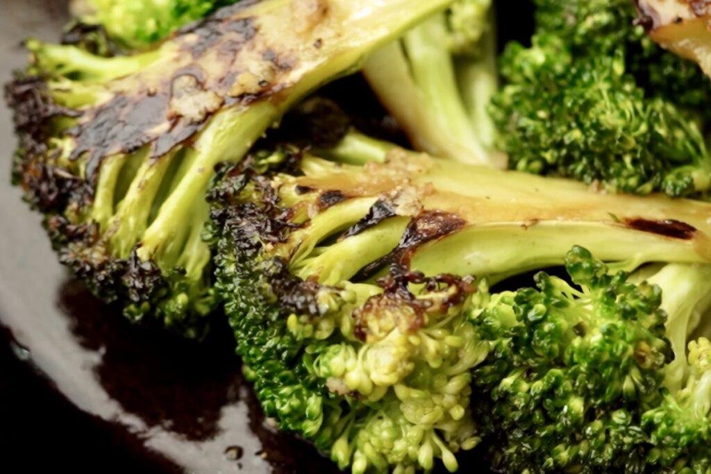 Close up of broccoli with charred, golden brown cut sides and bright green florets