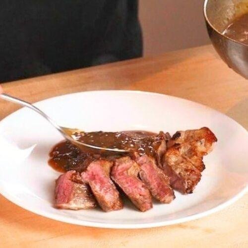 slices steak on a plate with mushroom pan sauce