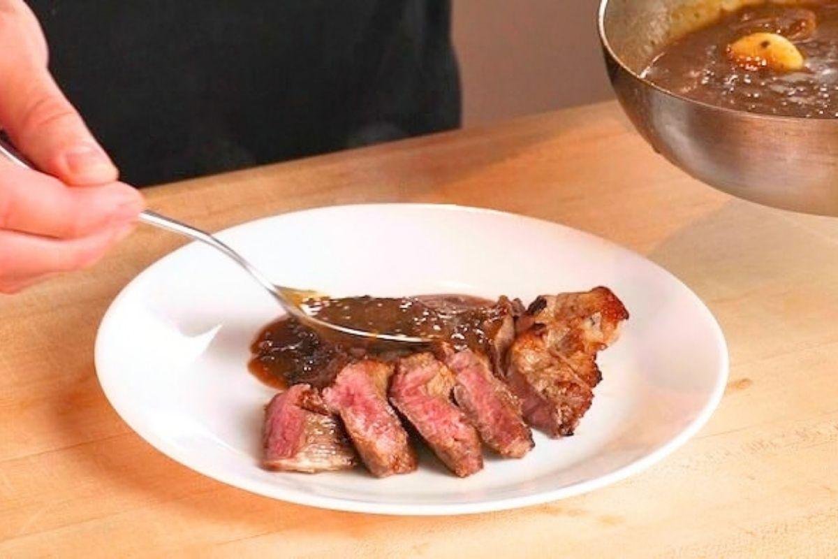 slices steak on a plate with mushroom pan sauce