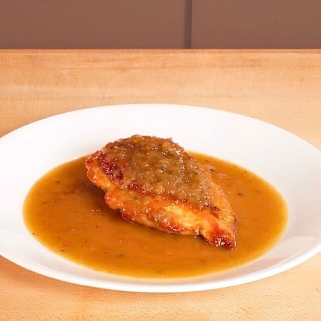 chicken breast on a plate with pan sauce