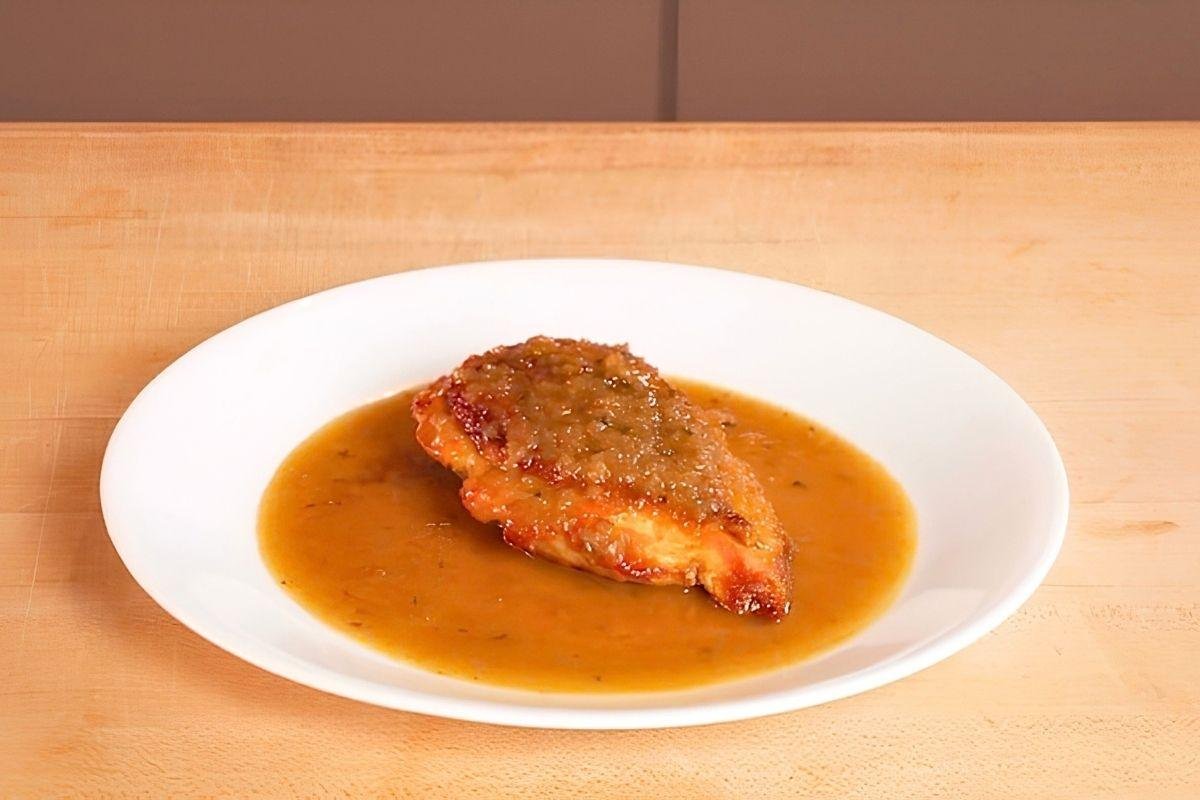 chicken breast on a plate with pan sauce