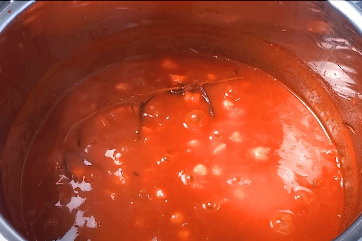 Chickpeas simmering in a rich tomato sauce in a steel pot