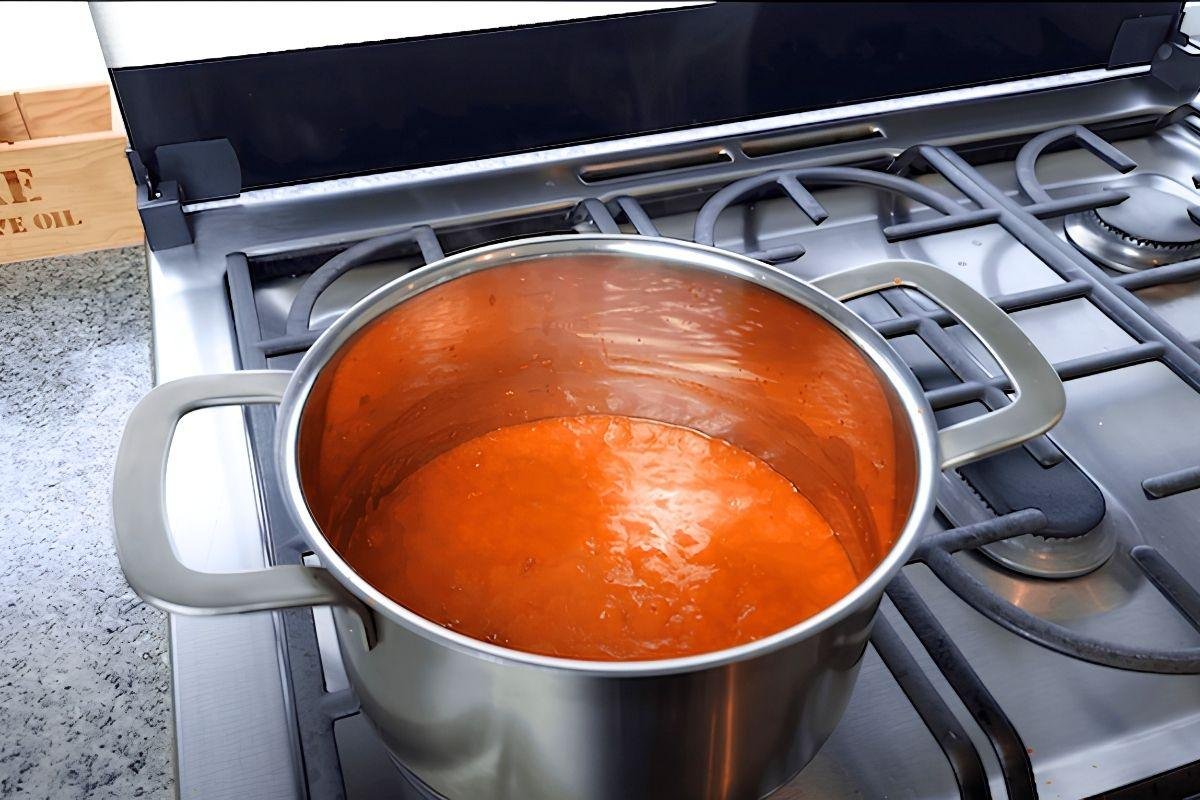Steel pot of smooth bravas tomato sauce on the hob