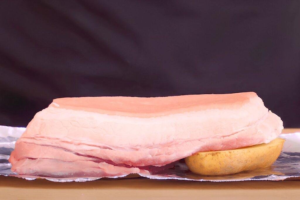 levelling out the pork belly using a vegetable