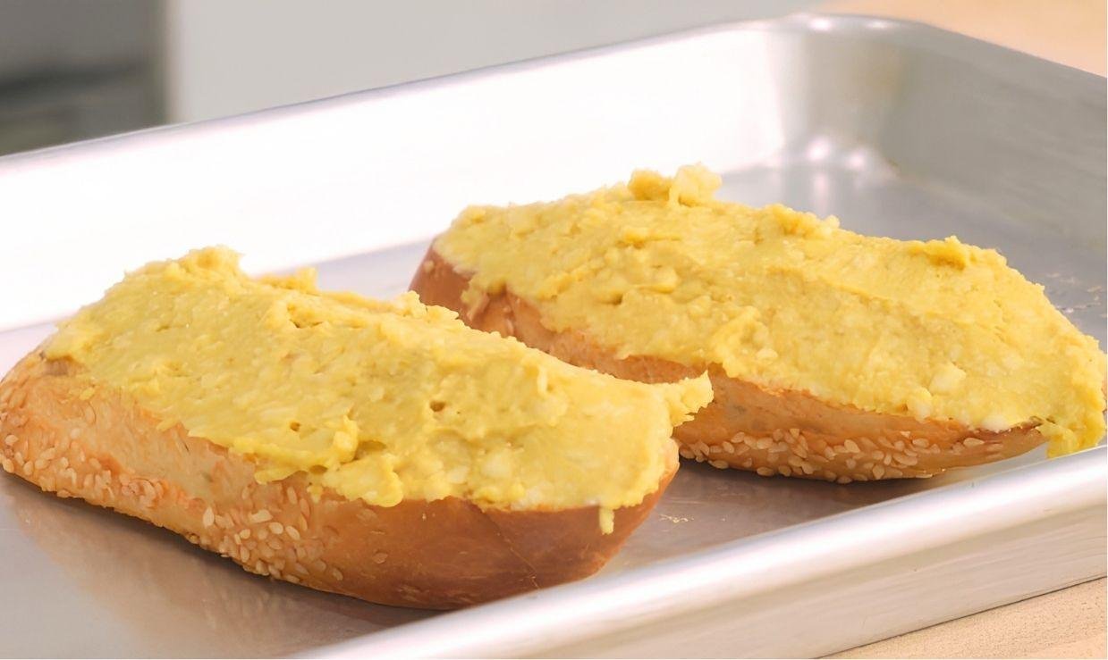 toast covered in raw rarebit mixture ready for grilling