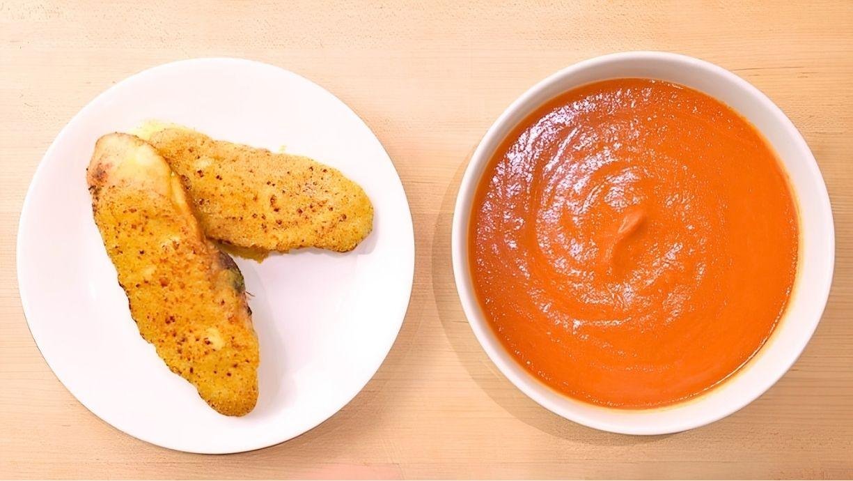 plate of golden brown rarebit and a bowl of hot tomato soup