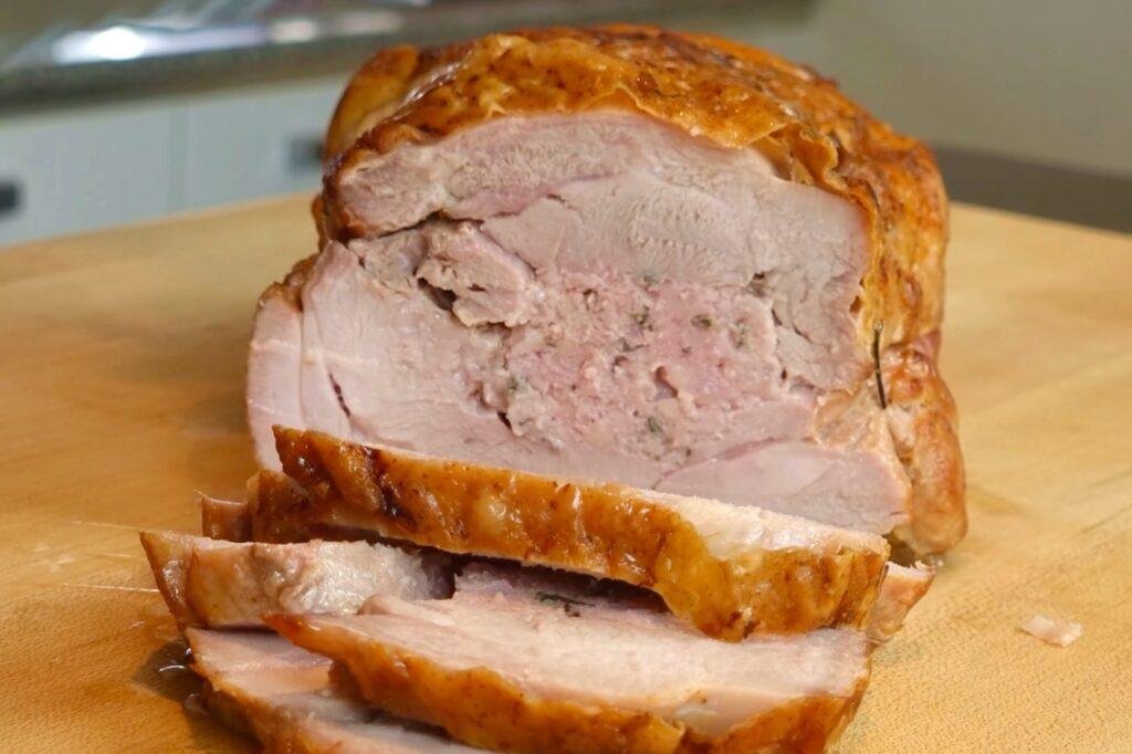 Slices cut from a golden roast rolled turkey joint with stuffing in the centre