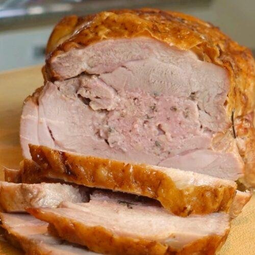 Slices cut from a golden roast rolled turkey joint with stuffing in the centre