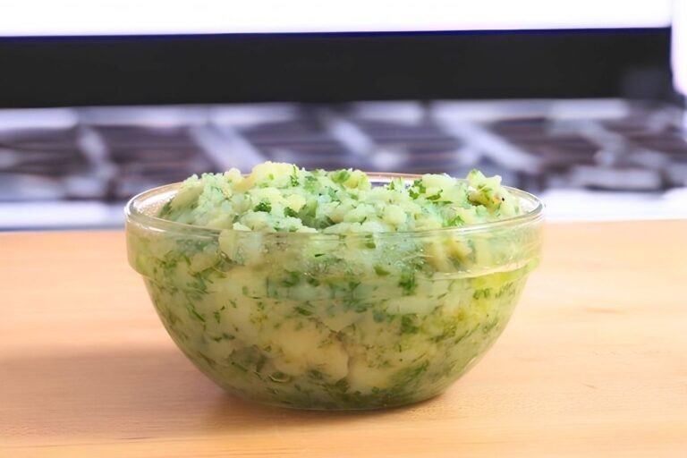 Glass bowl of skordalia, a mashed potato and garlic dip with chopped fresh herbs