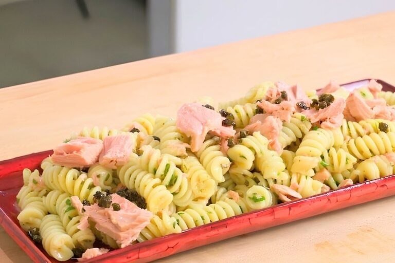 Red platter of fusilli pasta salad with flaked tuna and crispy capers