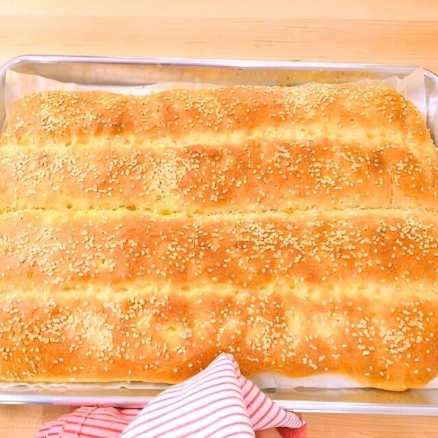 Sesame topped Turkish flatbread fresh from the oven in a metal baking tray