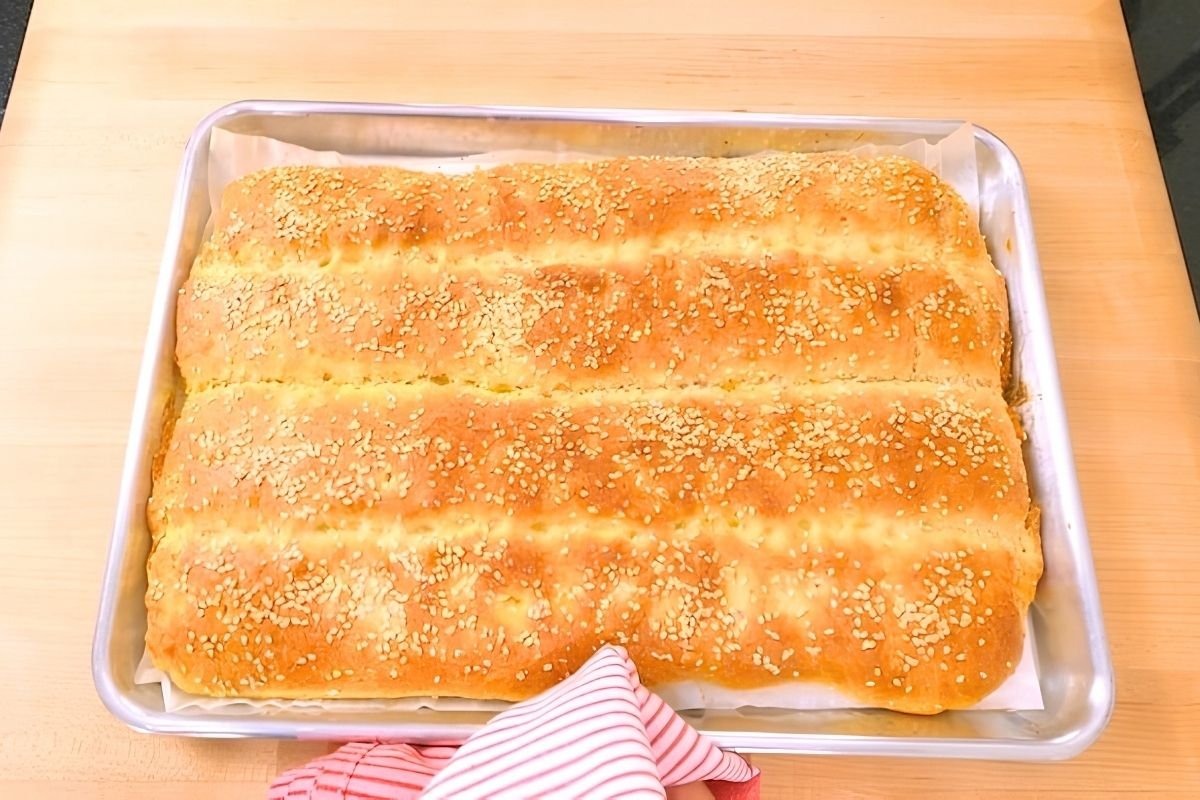 Sesame topped Turkish flatbread fresh from the oven in a metal baking tray