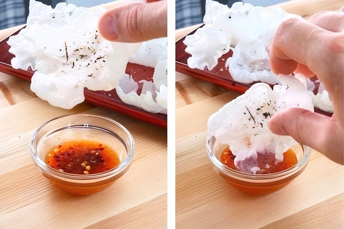 A vegan prawn cracker being dipped in sweet chilli sauce