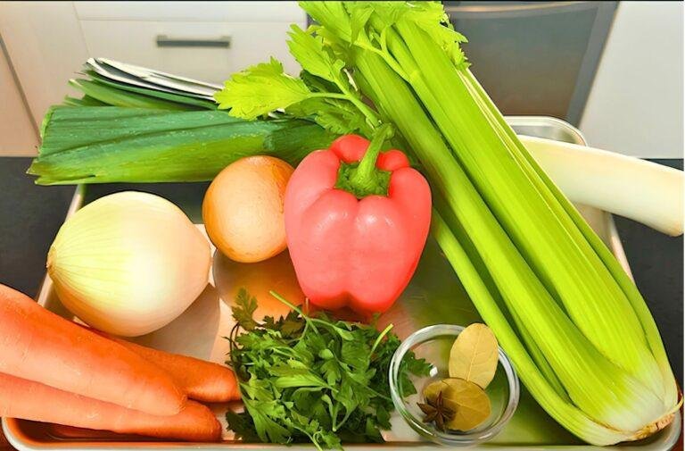 Vegetables for stock on a tray: leek, onion, carrots, red pepper, celery, parsley and bay leaf