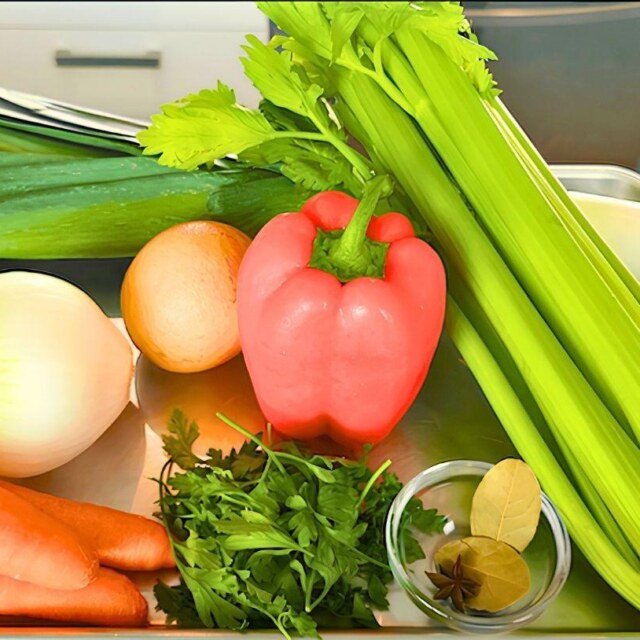 Vegetables for stock on a tray: leek, onion, carrots, red pepper, celery, parsley and bay leaf