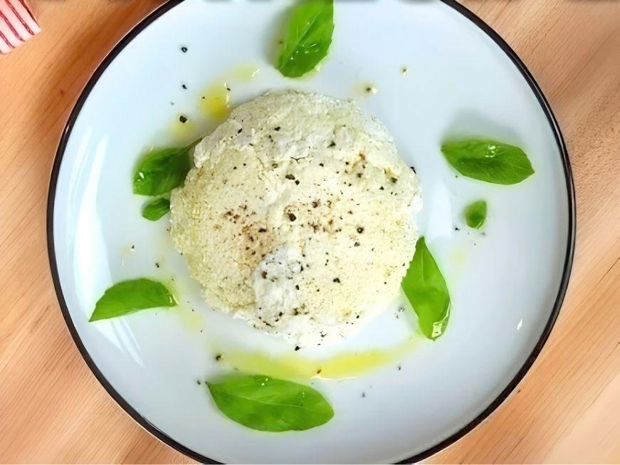 Plate of fresh homemade ricotta with olive oil and basil