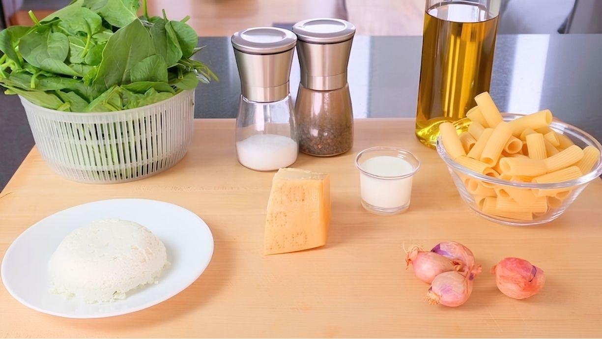 Ingredients for spinach and ricotta pasta laid out: spinach, ricotta, parmesan, rigatoni, shallots, olive oil, salt and pepper